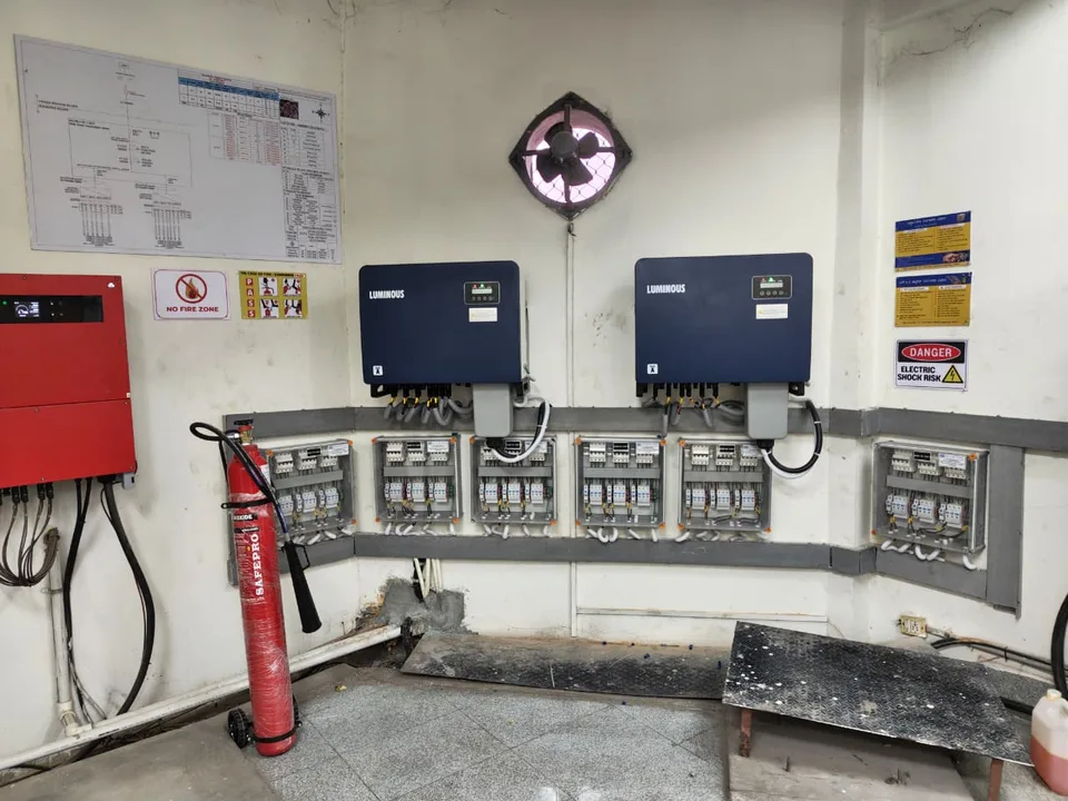 Inverter room with a red ACDB panel and a single-line diagram chart on the wall