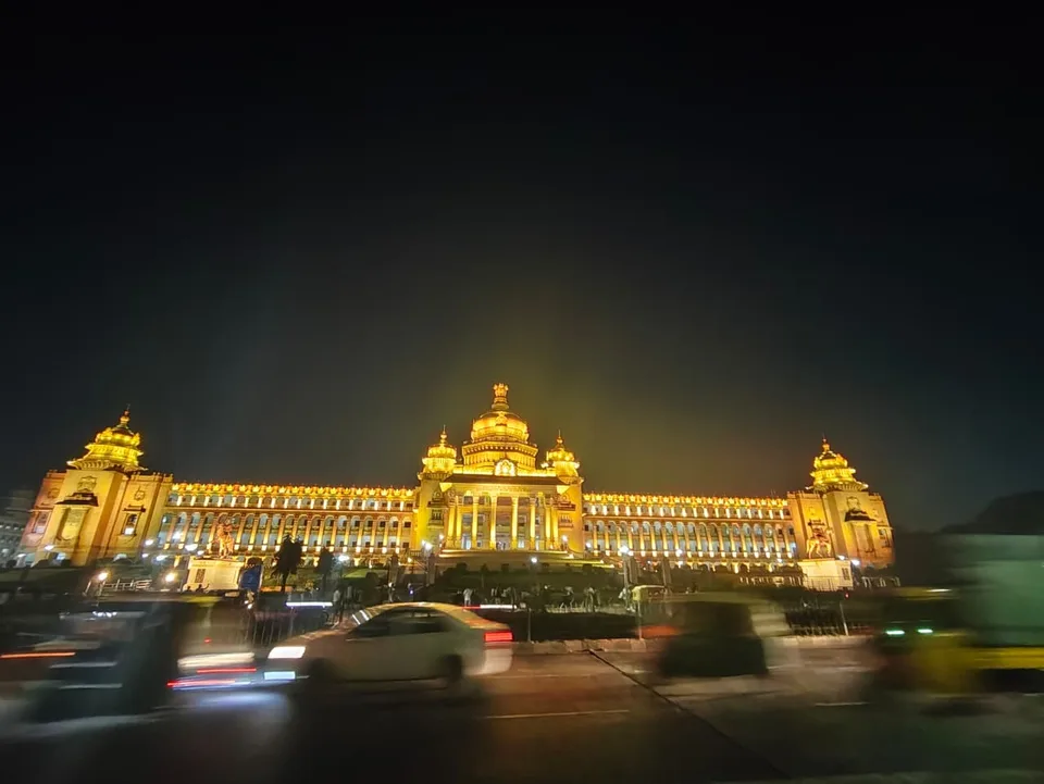 The Vidhana Soudha in Bengaluru lit in gold at night, its granite facade and domes illuminated
